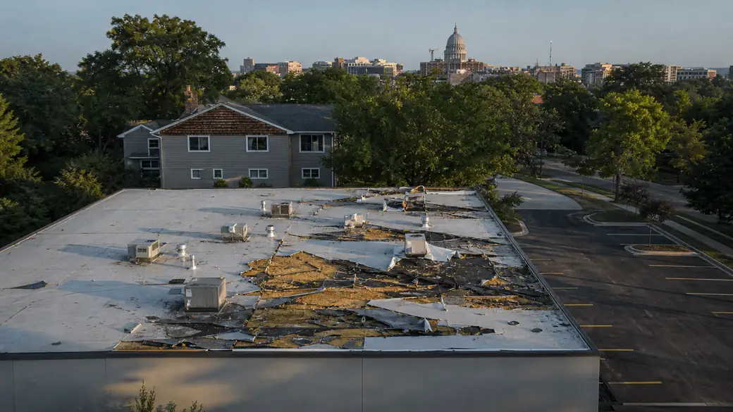 emergency roof repair completed by a local contractor at a grey split-level home in Madison, WI, in late afternoon light.