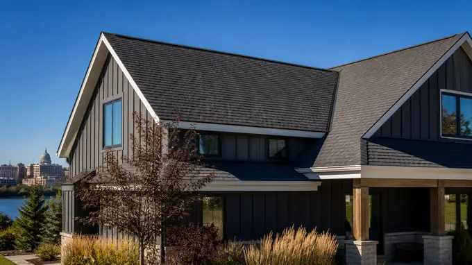 A contractor and homeowner walk the yard for a final look at the completed roof. at a charcoal farmhouse-modern home in Madison, WI.